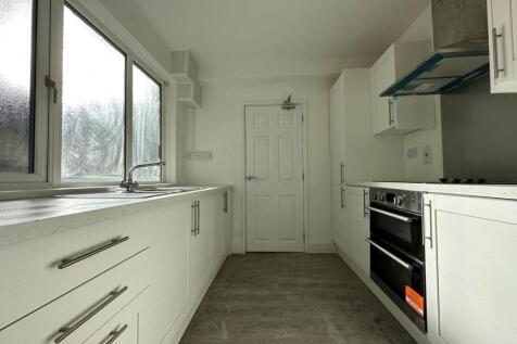 A bright and modern kitchen with ample natural ...