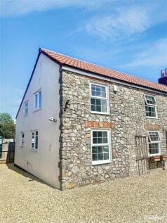 Charming stone cottage with a sunny exterior....