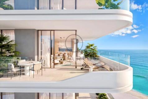 Modern beachfront apartment balcony with furniture