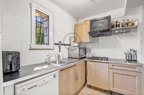 A compact kitchen featuring wooden cabinets, a sta