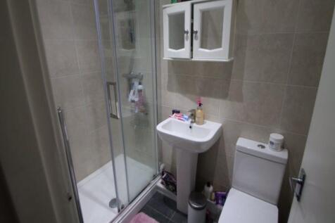 A modern bathroom suite featuring a glass-enclo...
