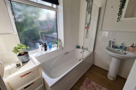 A spacious, clean bathroom featuring a large ba...