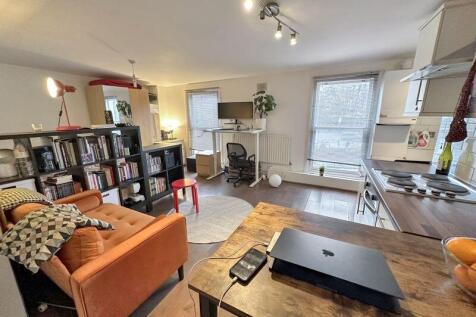 A bright and modern first-floor studio apartment ideally located on Roman Road. The property features an entrance hallway leading to a generous open-plan living space cleverly arranged into four disti