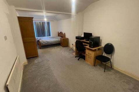 Long rectangular bedroom with a double bed at t...