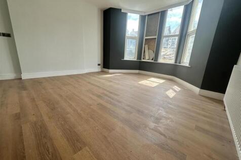 Sunlit living room with modern wood flooring...
