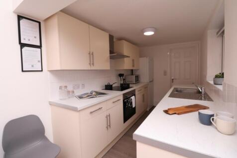 A modern and tidy kitchenette featuring ample s...