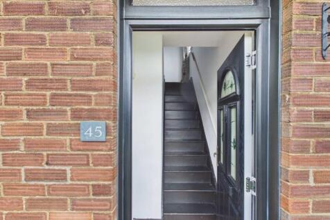 Wooden stairs and a tiled floor in the entrance ha