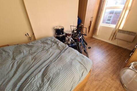 A cozy bedroom with a bed, some personal items,...