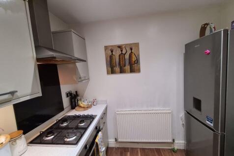 A modern kitchen with white cabinets, a gas sto...