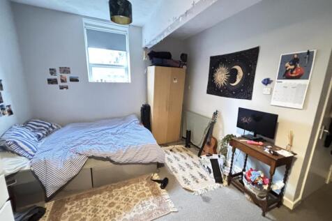 A cozy bedroom featuring a comfortable bed, som...