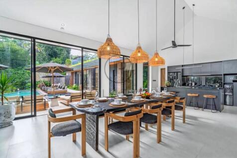 A modern dining area with a long wooden table set