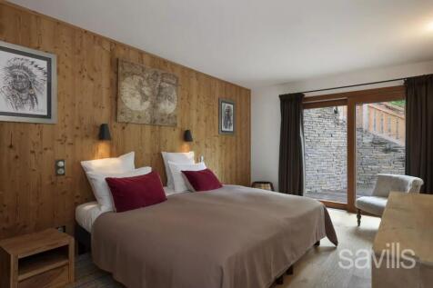 A cozy bedroom with twin beds, featuring wooden wa