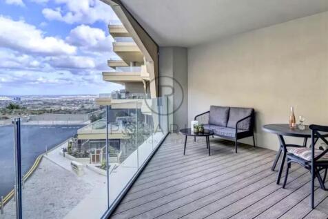 A modern balcony with glass railings features a sm