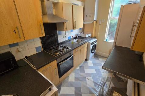 Bright galley kitchen with fitted cabinets, int...