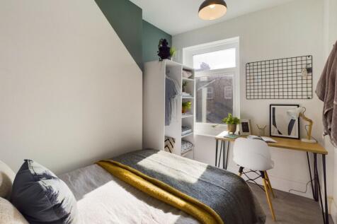 A modern, well-lit bedroom featuring a comforta...