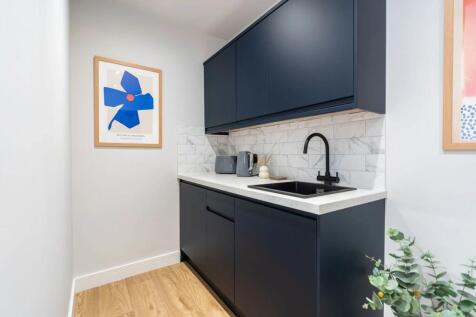 Modern and sleek kitchen with navy blue cabinet...