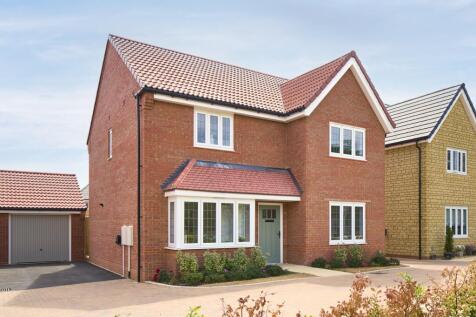 A modern red brick house with a bay window and a garage sits on a paved driveway
