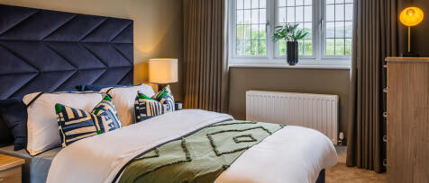 Redrow master bedroom with headboard, subtle lighting and window with floor to ceiling curtains