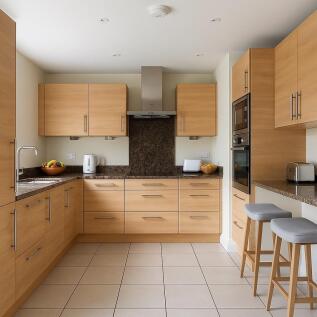 Kitchen with staged fruitbowl, kettle, stools etc