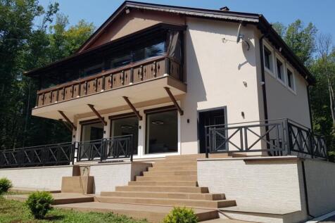 Side perspective showing balcony with wooden railing and stairs leading to terrace