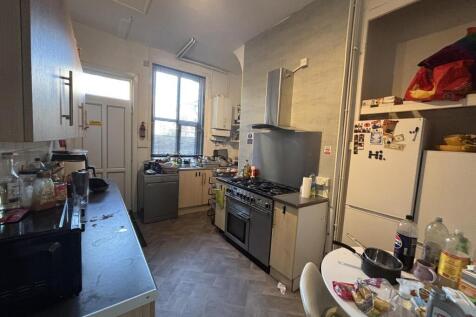 Bright galley kitchen with large window providi...