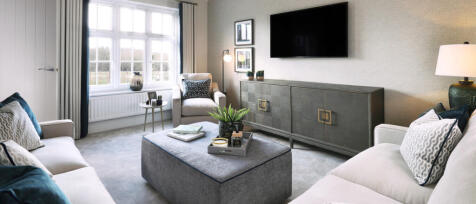 Modern living room with large window, grey carpet, cream sofas, TV mounted on wall, and coffee table