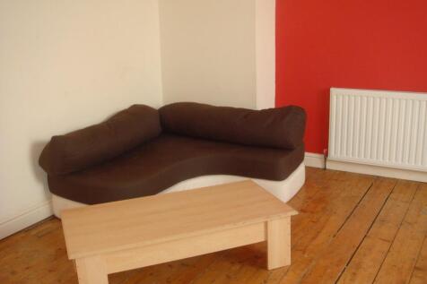 A cozy living room featuring a dark brown sofa,...