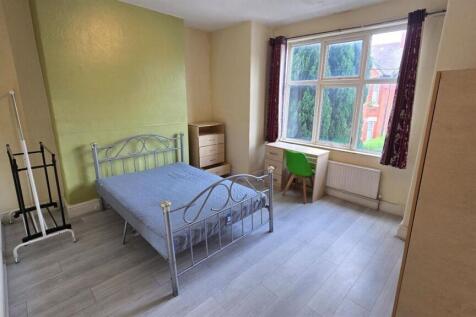 Bright double bedroom with a metal-frame bed, l...