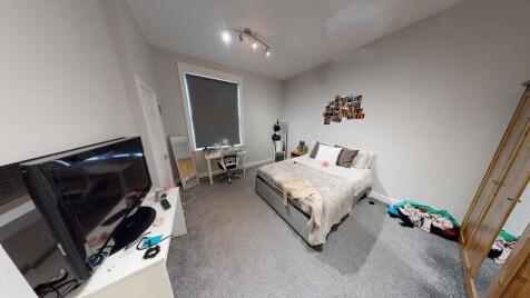 A well-lit, tidy bedroom featuring a double bed...