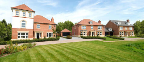 Three newly built detached brick houses with well-maintained lawns and a garage, set in a suburban n