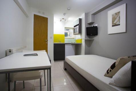 Modern open-plan studio in Holland Park with oak floors, a sleek kitchenette, and private en-suite shower. Furnished with a double bed, wardrobe, and dining set. Rent includes electricity, gas, and wa