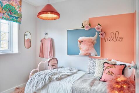 A child's bedroom features a pink bed with a fluffy blanket in the foreground
