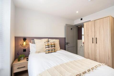 A spacious and well-lit master bedroom featurin...