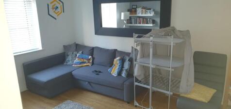 Bright, modern living area with an L-shaped gre...