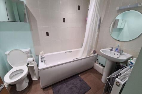 A well-maintained bathroom featuring a bathtub ...