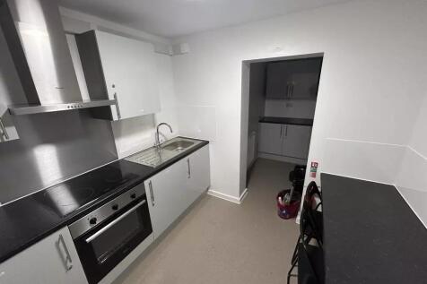 Modern galley kitchen with sleek white cupboard...