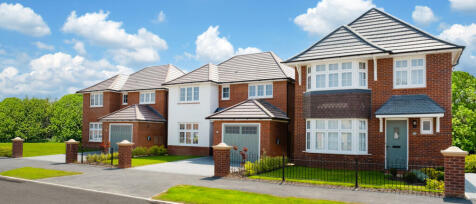 A row of modern semi-detached red-brick houses with grey tiled roofs, white window frames, and small