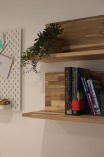 Neatly styled wooden wall shelves with a potted...
