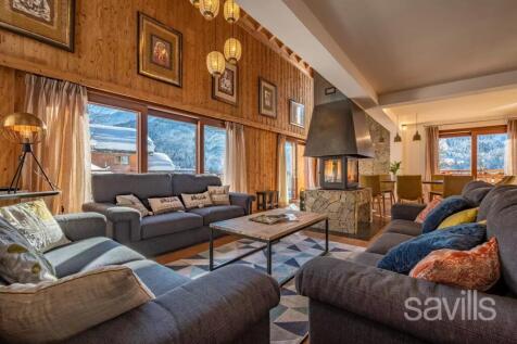 A cozy living room features plush sofas, a large f