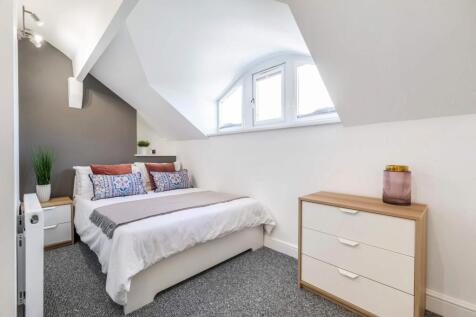 Bright and inviting master bedroom with a comfo...