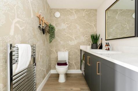 A guest cloakroom with space for laundry appliances completes the home