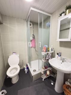 A clean bathroom featuring a shower enclosure w...