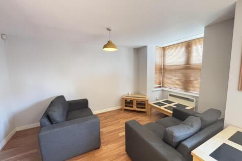 A modern, well-lit living room featuring comfor...