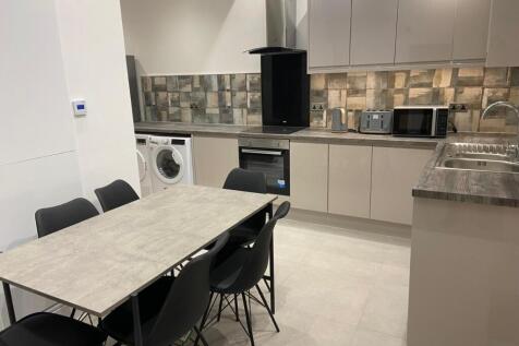 Modern open-plan kitchen with integrated applia...