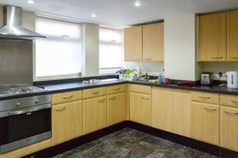 A bright, modern kitchen with light wooden cabi...