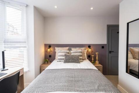 A stylish and well-lit double bedroom featuring...