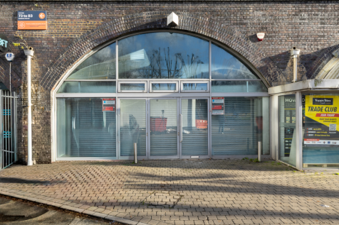 An empty arch with white lining and full height glazing to the front.
