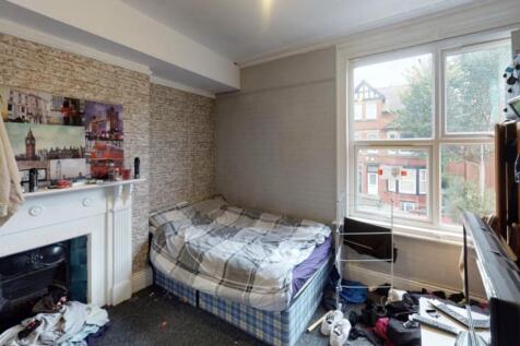 A cozy bedroom with a single bed placed near a ...