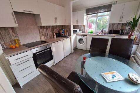 A modern, well-lit kitchen with white cabinetry...
