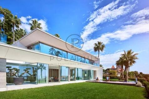 A modern, two-story house with large glass windows